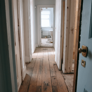 Hallway of an old house with worn and damaged wooden flooring during renovation